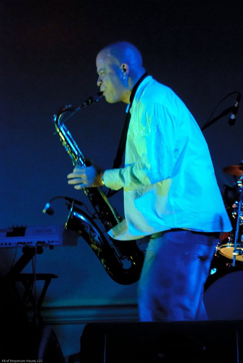 Saxophonist performing under blue stage lights