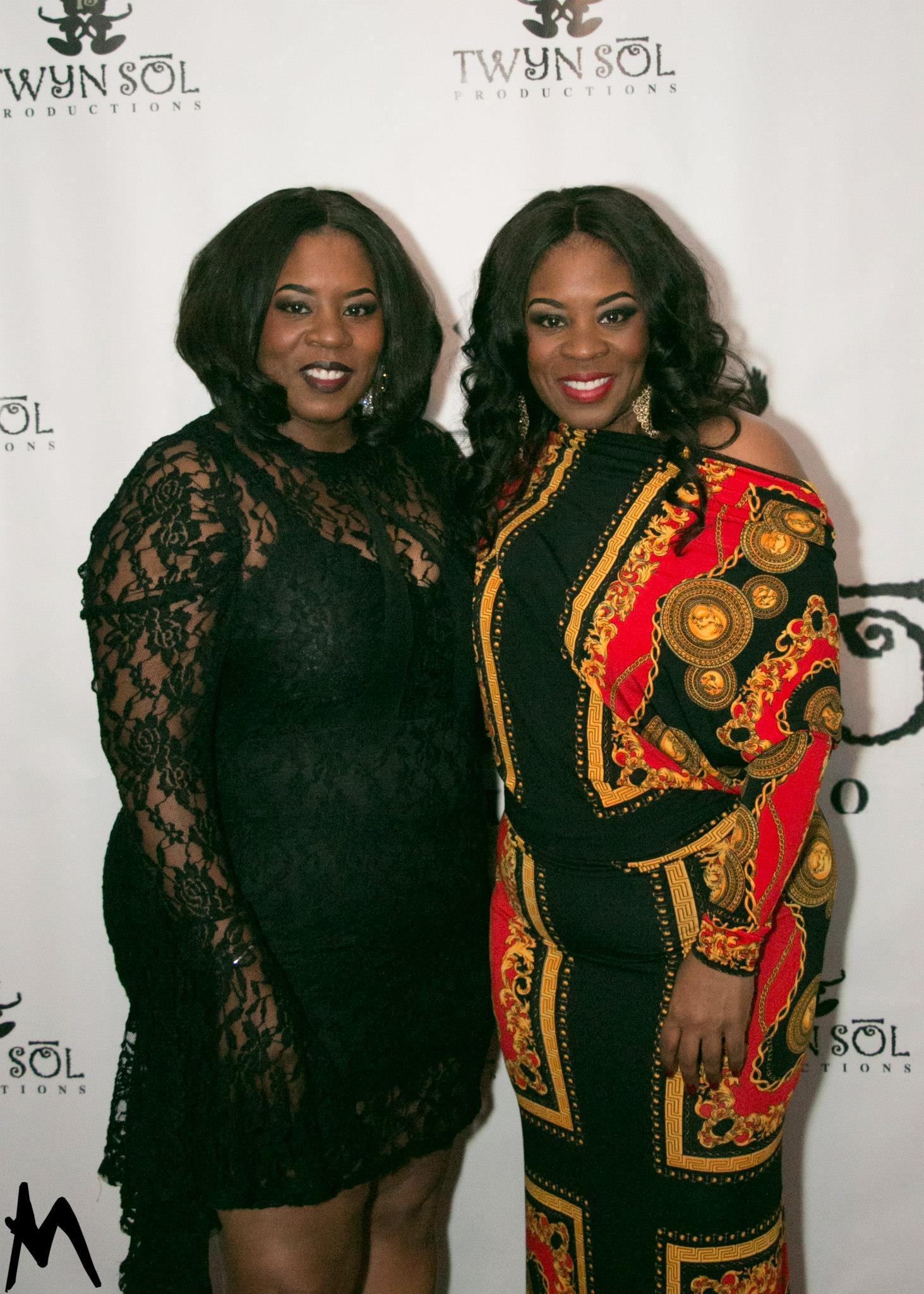 Two guests posing at the Twyn Sol step-and-repeat