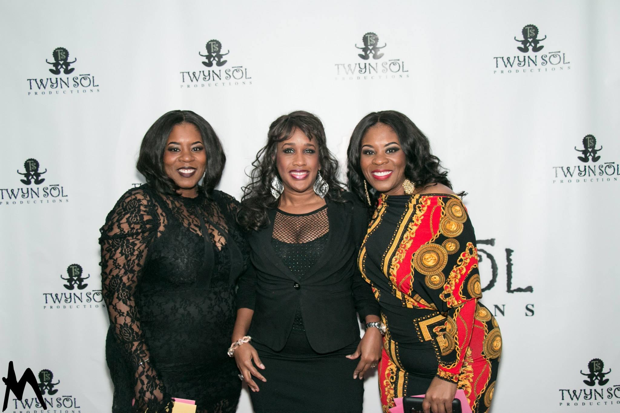 Three guests posing together at the Twyn Sol backdrop