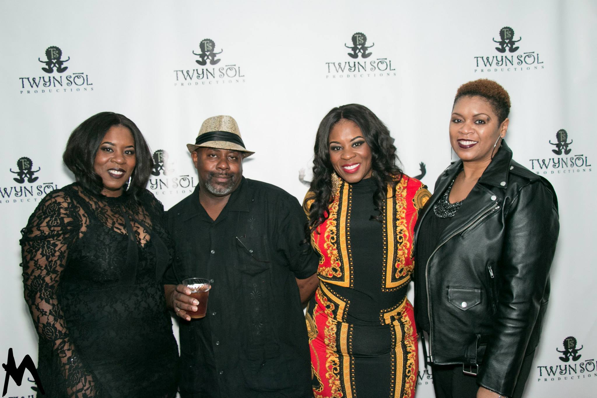 Four guests posing together at the Twyn Sol event backdrop