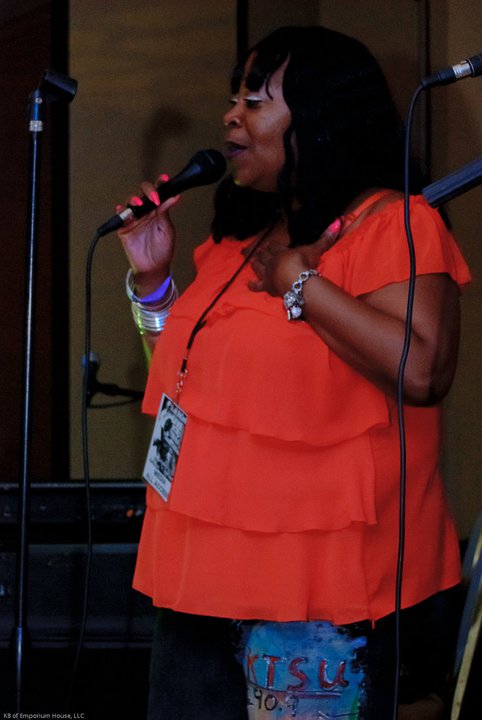 Vocalist performing live in an orange top