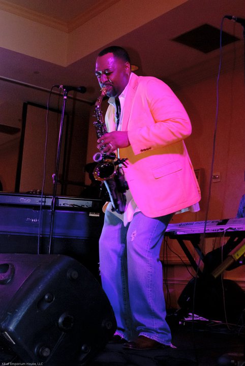 Saxophonist performing on stage in a bright jacket
